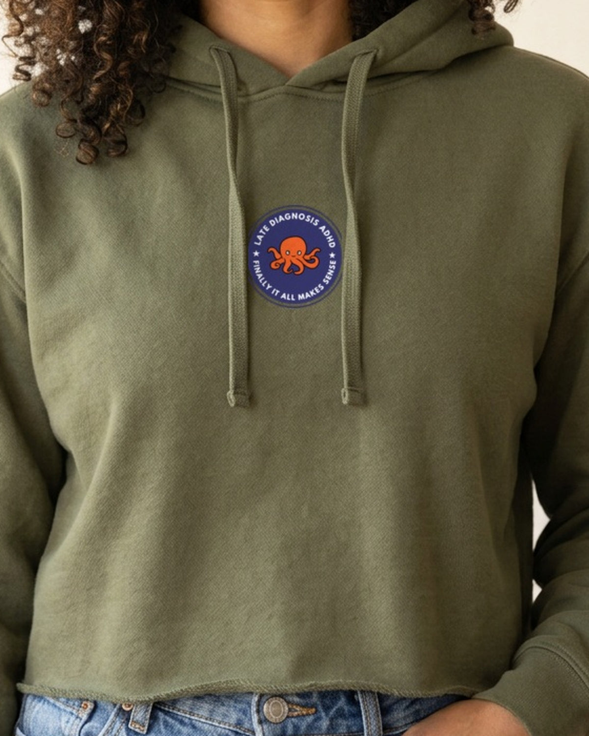 Olive crop hoodie with the embroidered Late Diagnosis ADHD badge: Finally it all makes sense