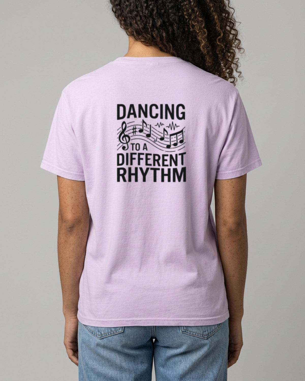 Back of a woman in a lilac tee printed Dancing to a Different Rhythm with music notes