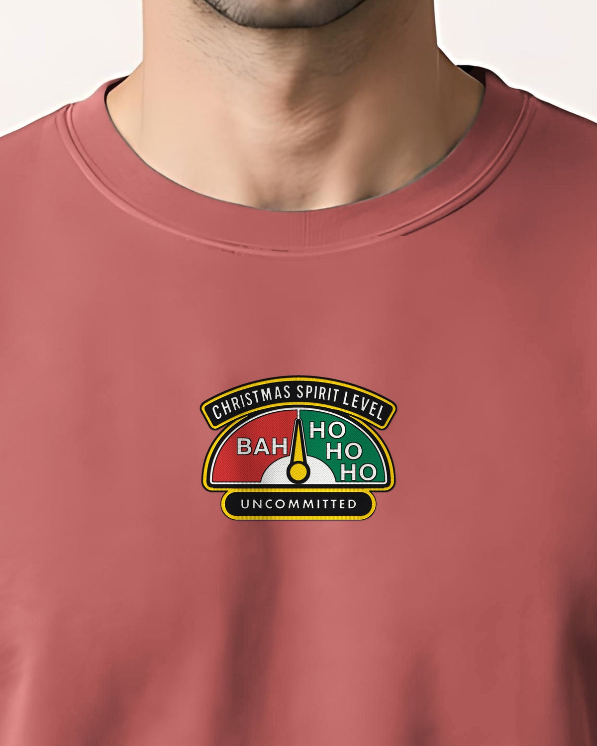 Close-up of a man in a crimson sweatshirt with the embroidered Christmas Spirit Level badge: Bah, Ho Ho Ho, Uncommitted