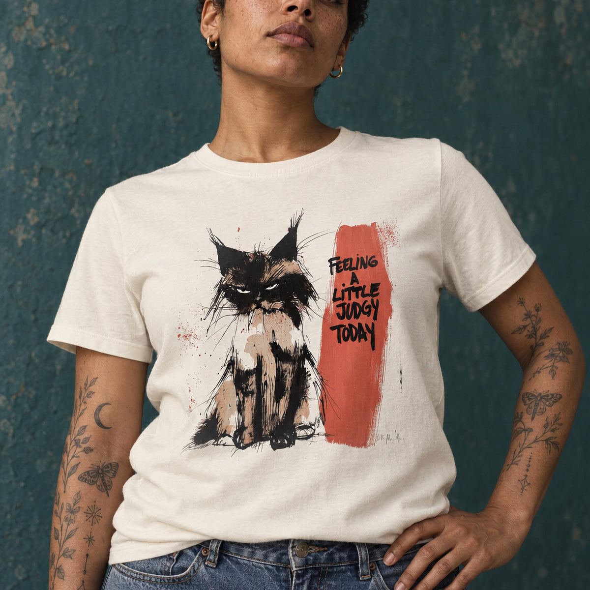 Woman in a natural-coloured organic cotton tee printed with a judgemental-looking cat and the words Feeling a little judgy today