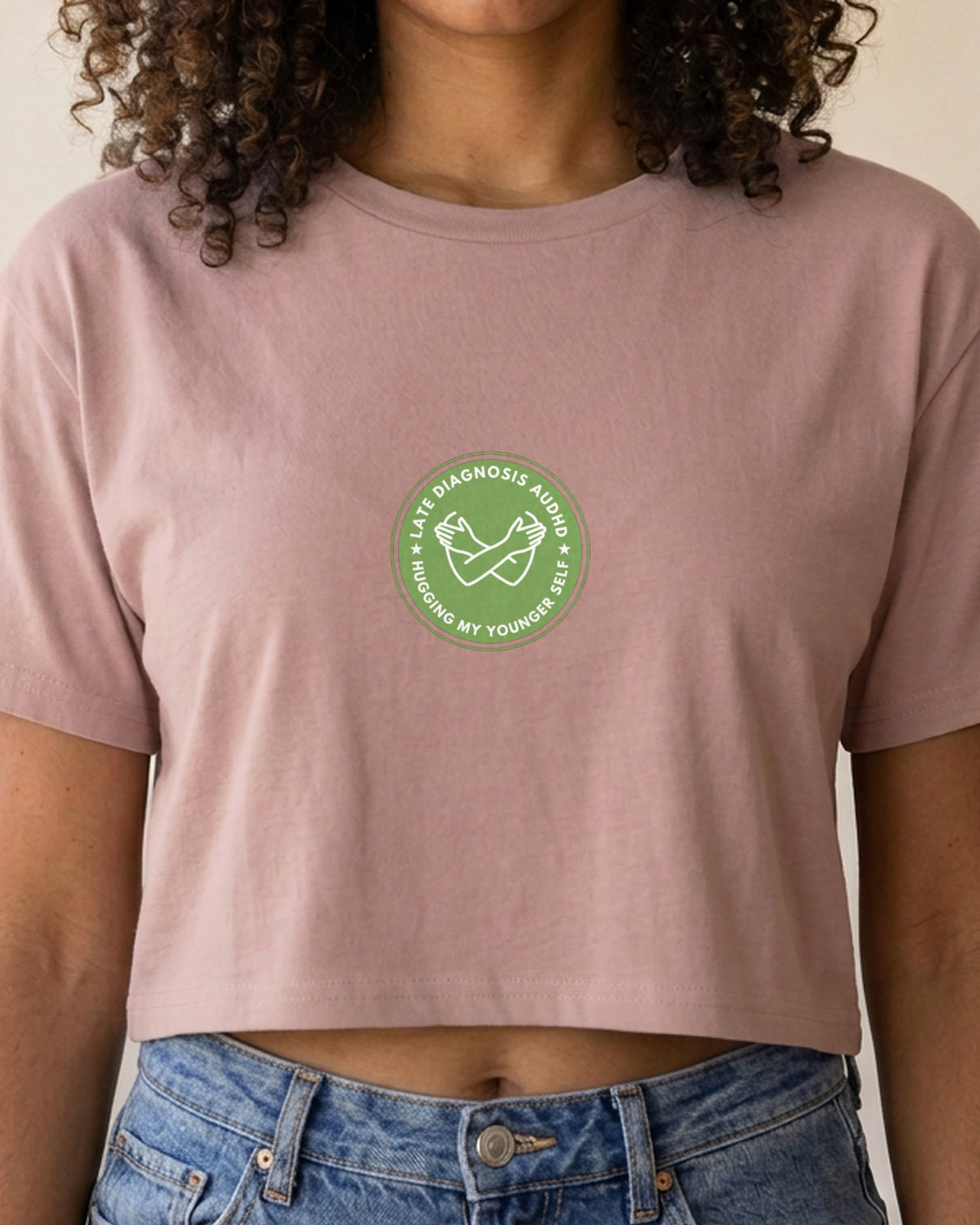 Hugging ... AuDHD embroidered crop top in Hazy Pink, worn, close-up of the embroidery