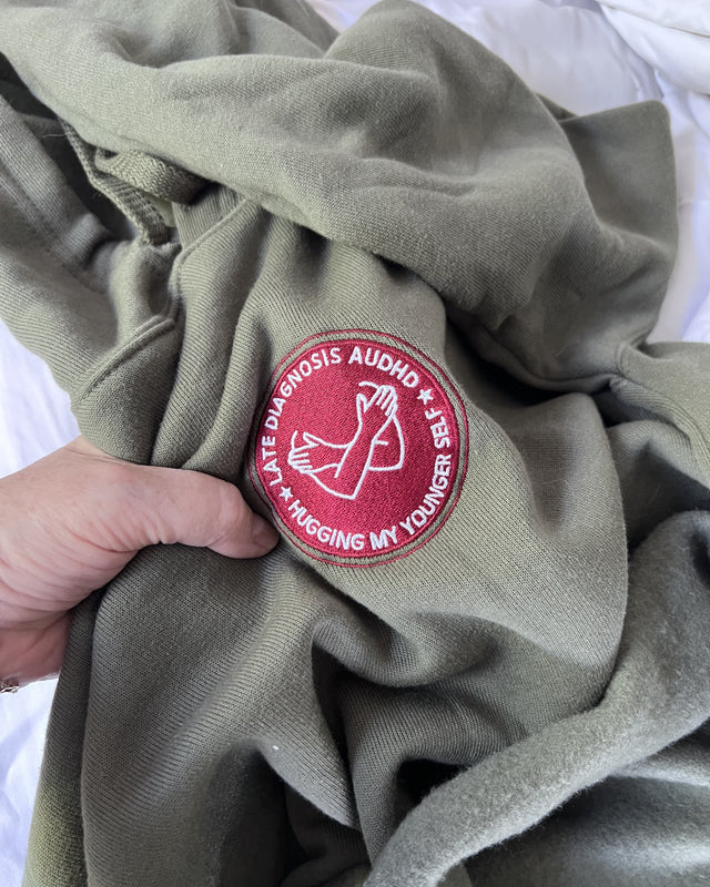 Hugging AuDHD embroidered crop hoodie, photographed by its owner