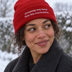 Woman in a red ribbed beanie embroidered with the words synapsing way faster than this conversation