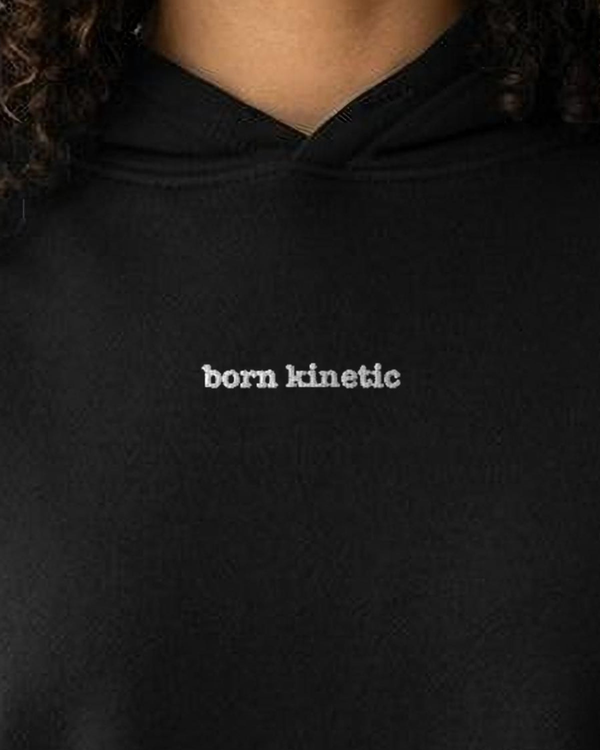 Born Kinetic embroidered crop hoodie in Black, worn, close-up of the chest design