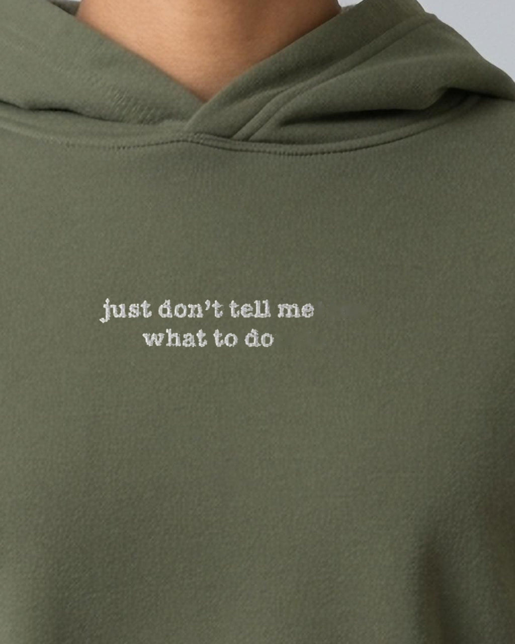 Just Don't Tell Me What to Do embroidered crop hoodie in Military Green, worn, close-up of the chest design