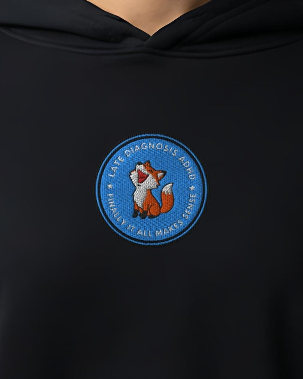 Finally ... AuDHD embroidered crop hoodie in Black, worn, close-up of the chest design