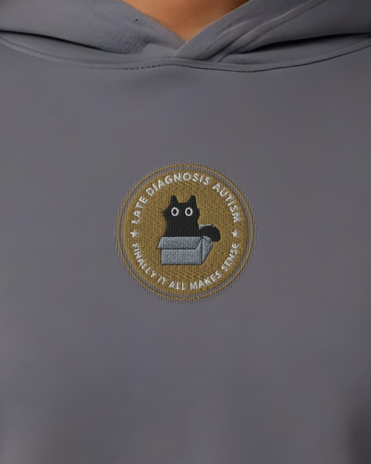 Finally ... Autism embroidered crop hoodie in Storm, worn, close-up of the chest design