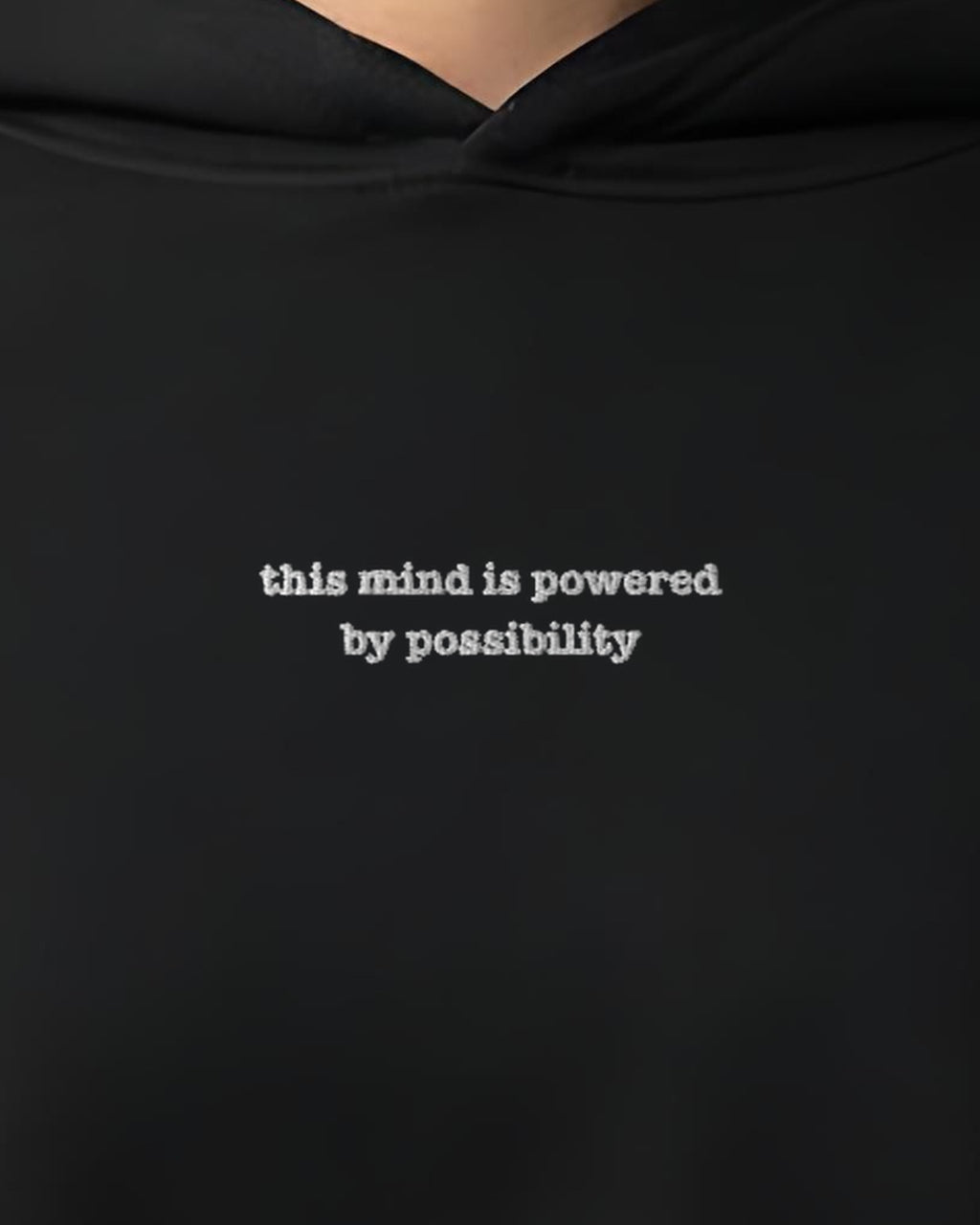Powered by Possibility embroidered crop hoodie in Black, worn, close-up of the chest design