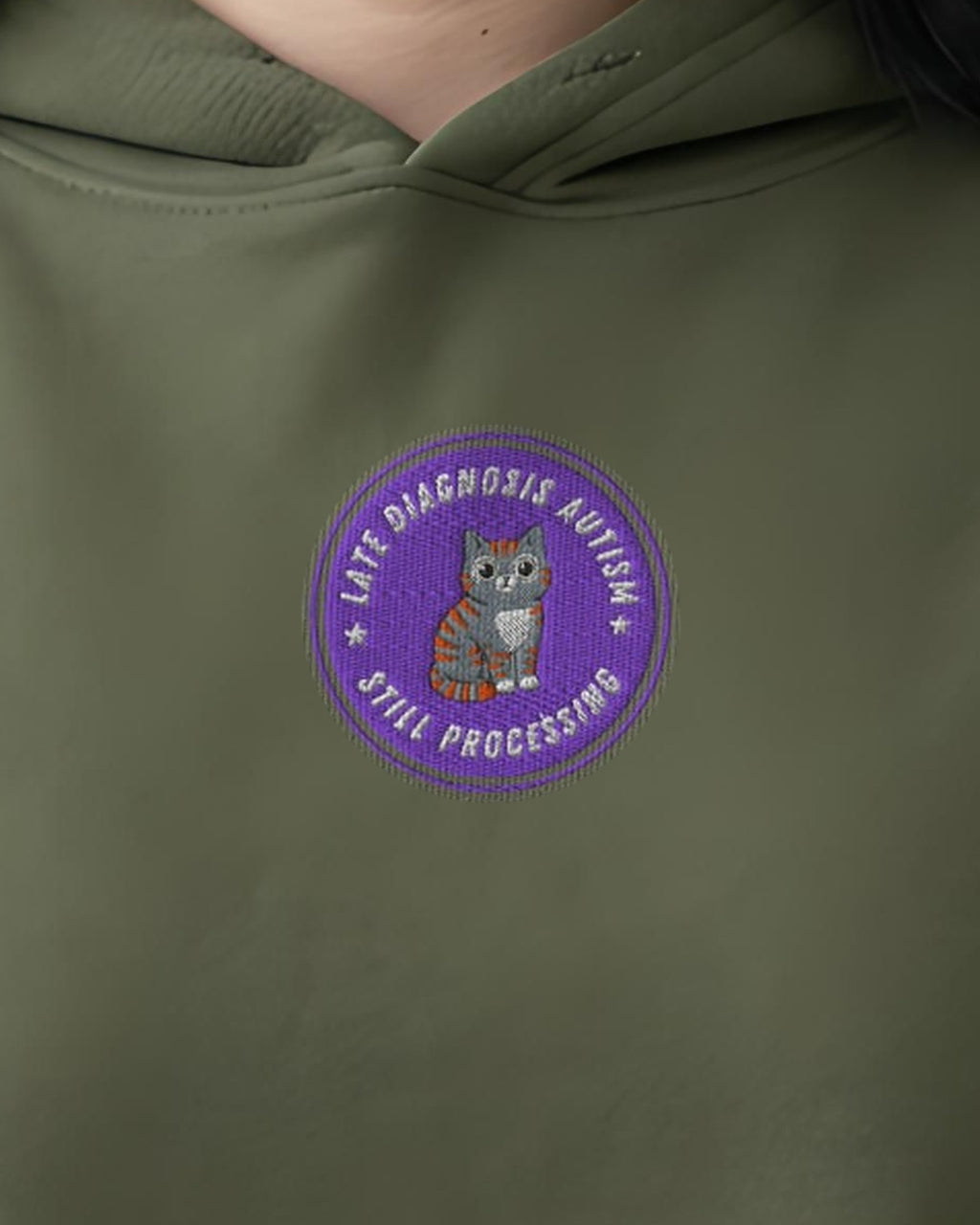 Still Processing ... Autism embroidered crop hoodie in Military Green, worn, close-up of the chest design