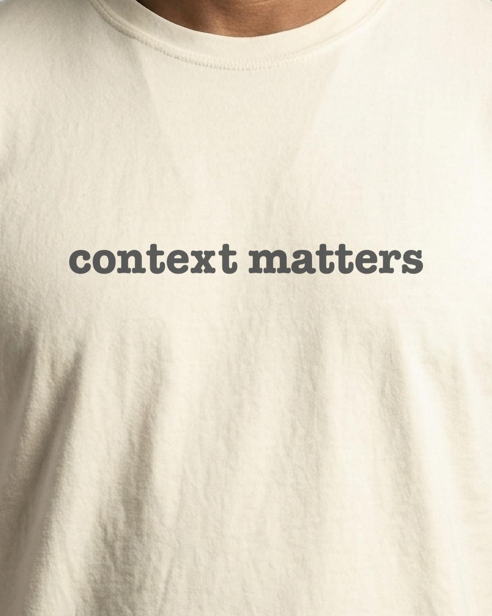 Context Matters garment-dyed tee in Ivory, close-up of the printed slogan