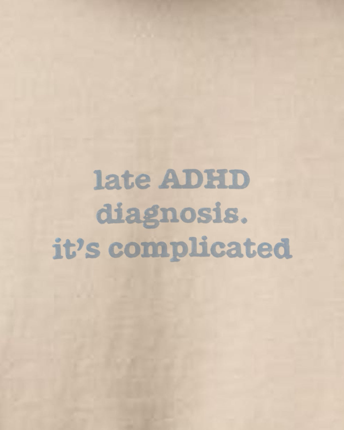 It's Complicated Phrase (ADHD) embroidered organic tee in Desert Dust, close-up of the embroidered slogan