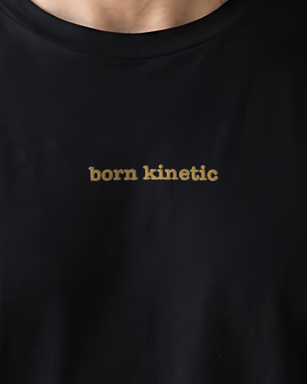 Born Kinetic embroidered organic tee in Black, worn, close-up of the chest embroidery