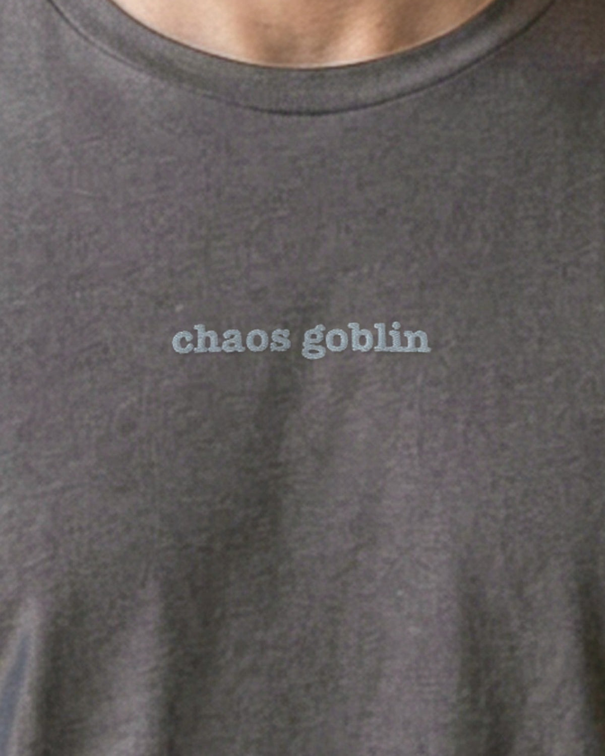 Chaos Goblin embroidered organic tee in Anthracite, worn, close-up of the chest embroidery