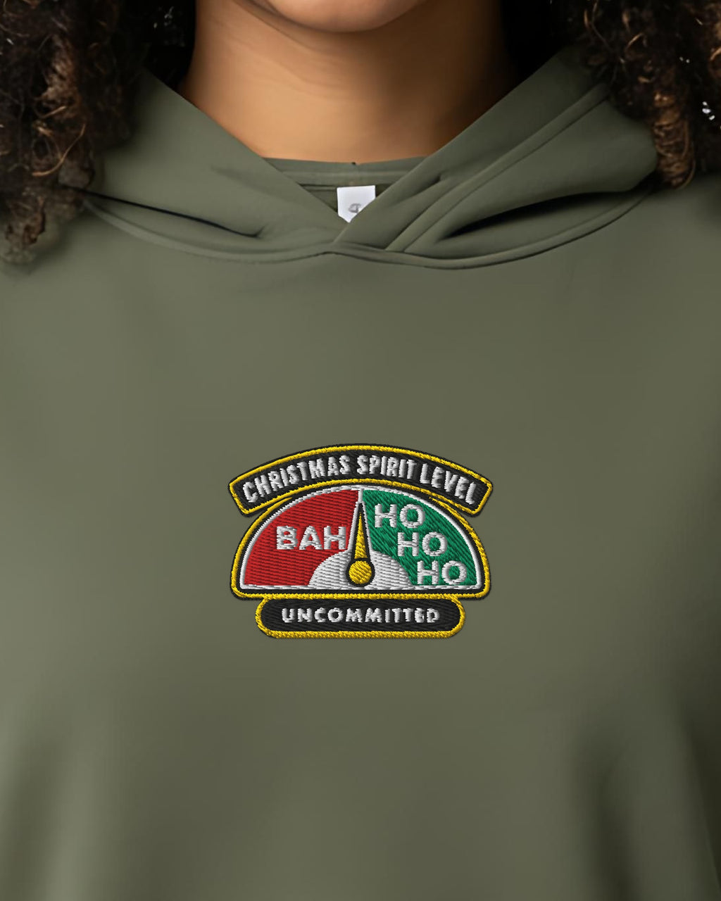 Christmas Spirit Level embroidered crop hoodie in Military Green, worn, close-up of the stitched gauge badge