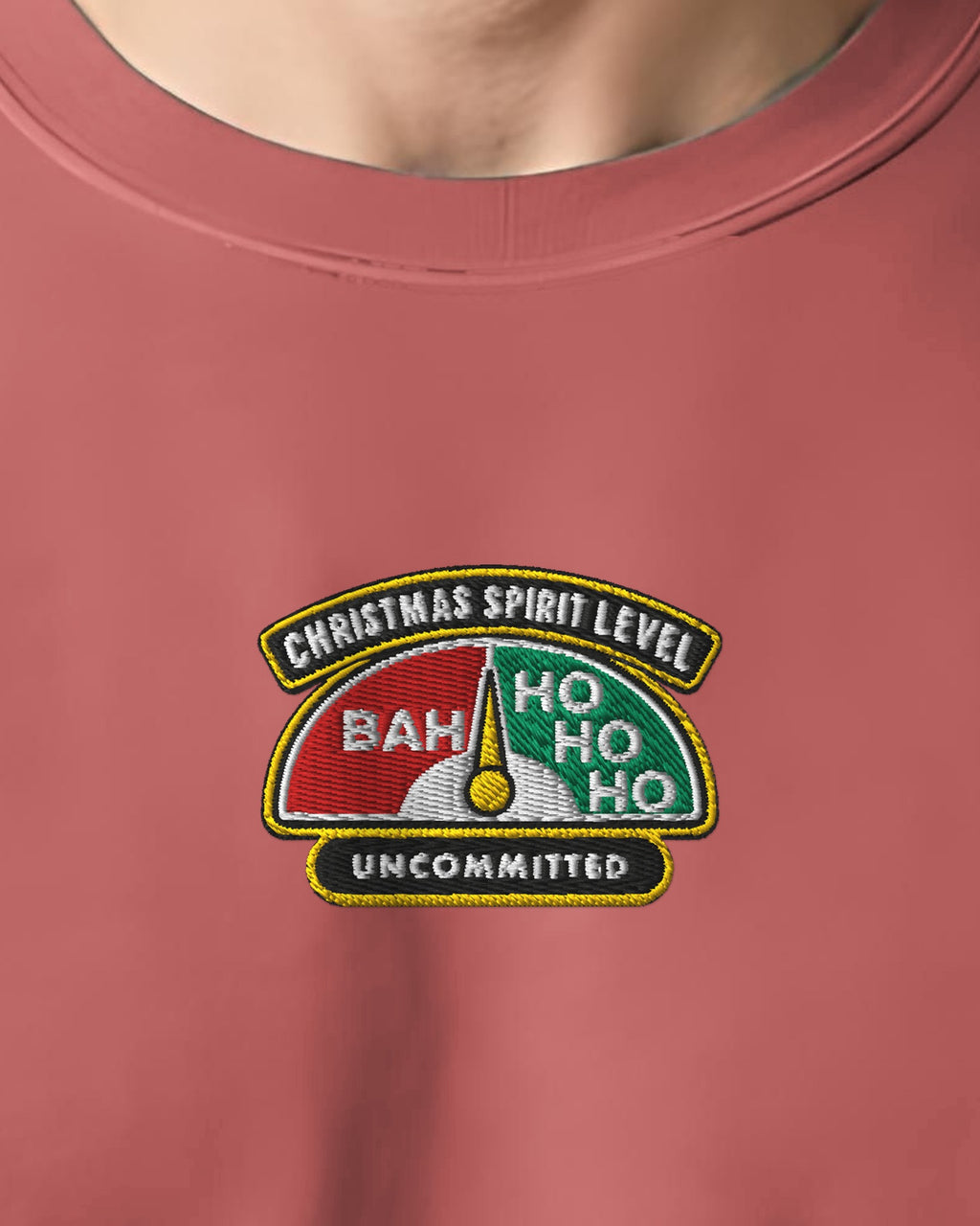 Close-up of the embroidered Christmas Spirit Level badge on the crimson sweatshirt