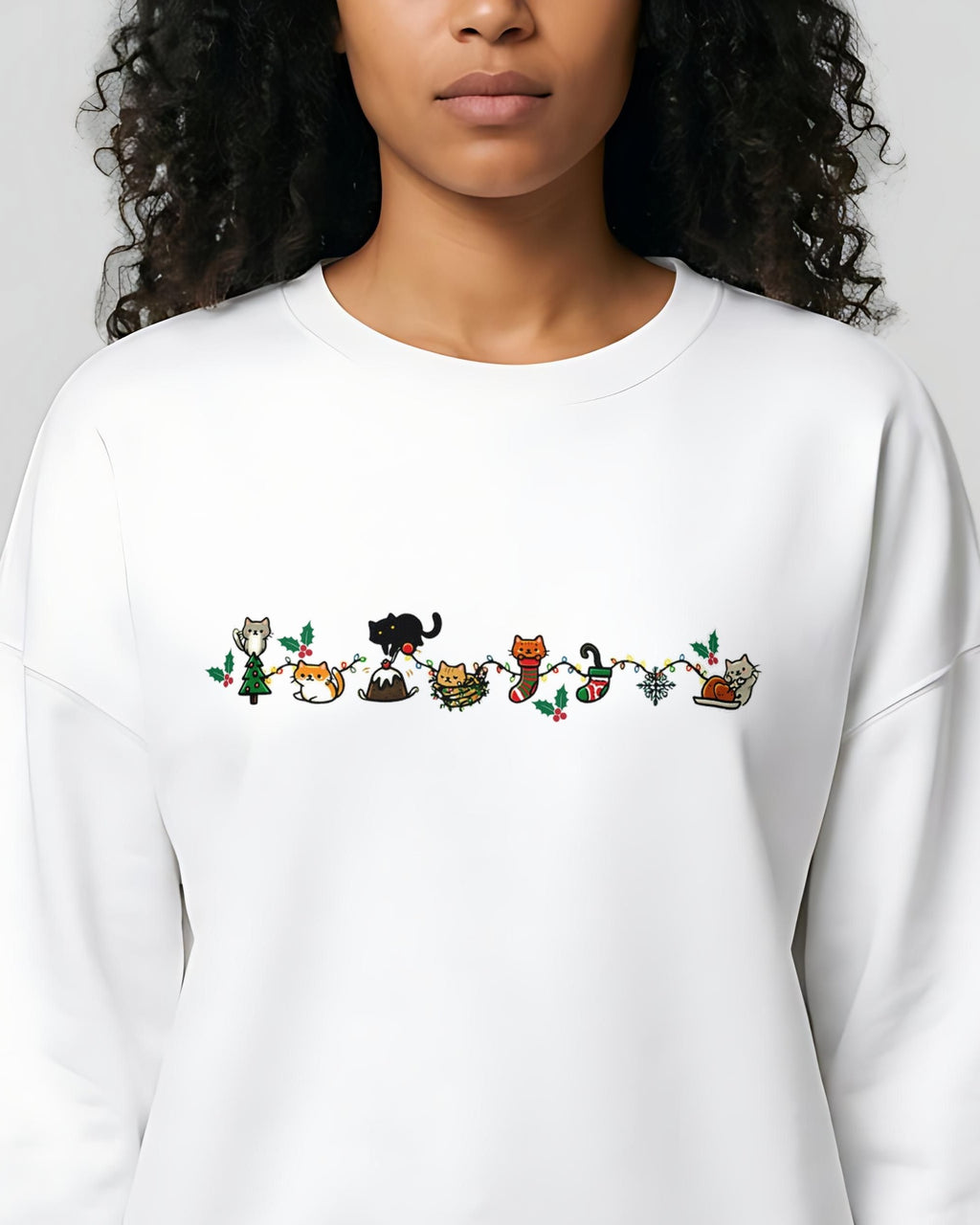 Cozy Catty Christmas women's organic sweatshirt in White, worn, close-up of the front design